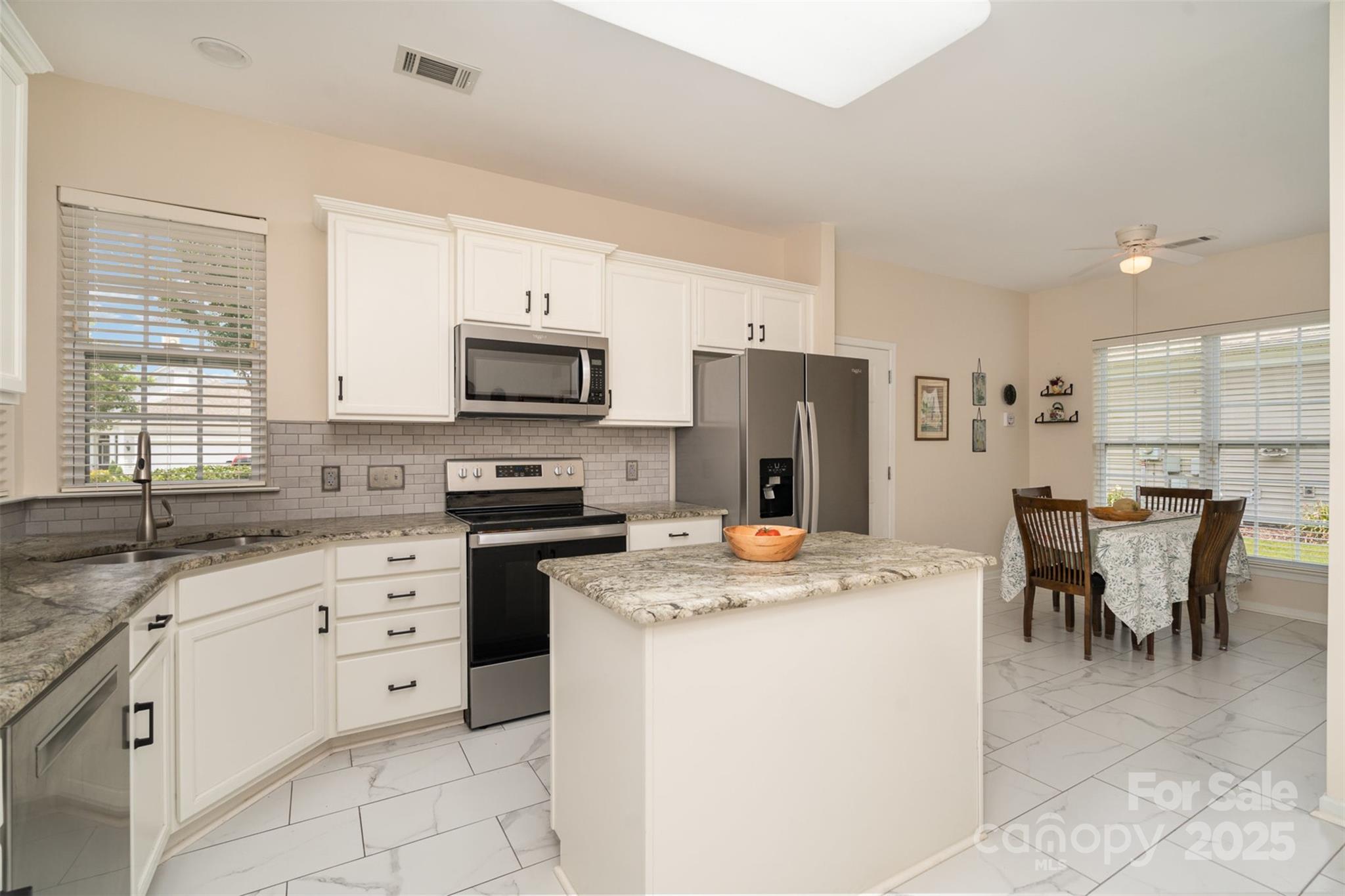 4079 Murray Street Fort Mill, SC 29707 - Photo 8 of 38 a kitchen with a stove a sink a microwave a dining table and chairs