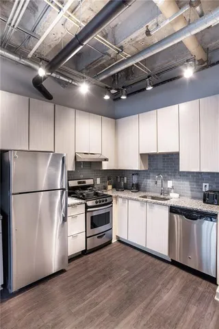 a kitchen with stainless steel appliances granite countertop a refrigerator a stove a sink and a microwave