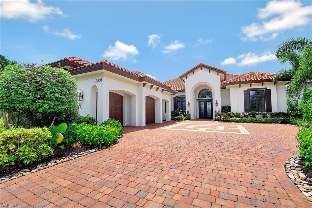 16434 Seneca Way Naples, FL 34110 - Photo 1 of 35 a view of a white house with a yard and potted plants