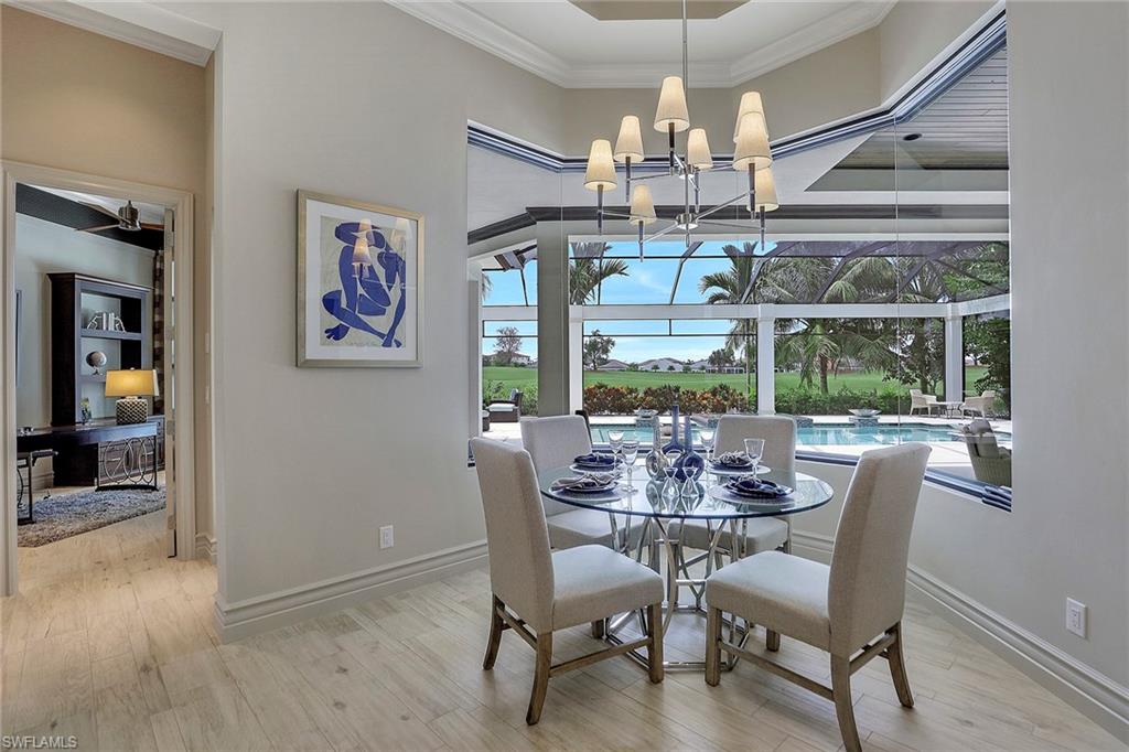 16434 Seneca Way Naples, FL 34110 - Photo 12 of 35 a dining room with wooden floor a chandelier a glass table and chairs