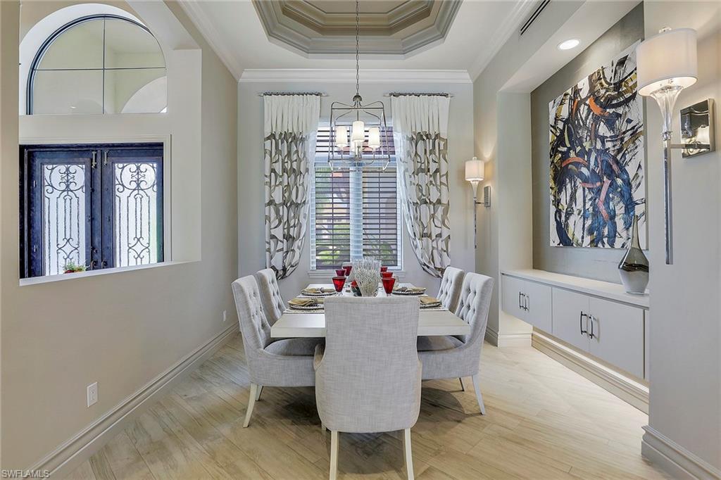 16434 Seneca Way Naples, FL 34110 - Photo 13 of 35 a view of a dining room with furniture a chandelier and wooden floor