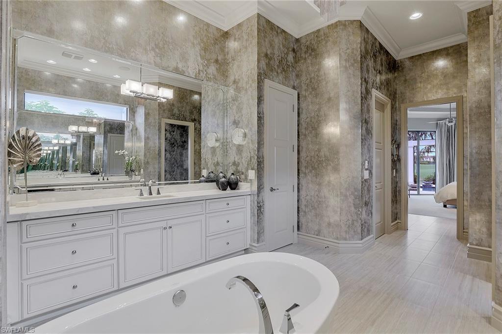 16434 Seneca Way Naples, FL 34110 - Photo 18 of 35 a spacious bathroom with a shower a sink and a mirror