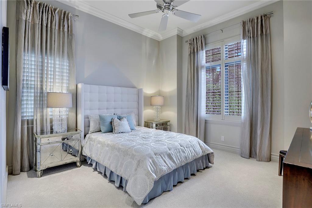 16434 Seneca Way Naples, FL 34110 - Photo 19 of 35 a bedroom with a bed and a chandelier