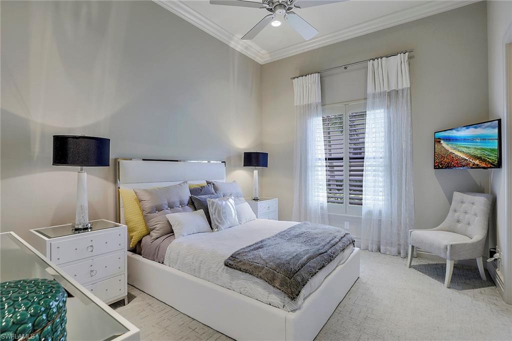 16434 Seneca Way Naples, FL 34110 - Photo 21 of 35 a bedroom with a bed a chair and a fireplace