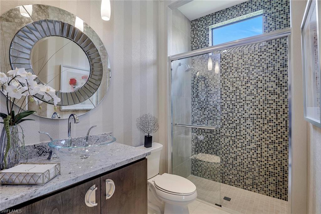 16434 Seneca Way Naples, FL 34110 - Photo 23 of 35 a bathroom with a granite countertop sink a toilet and shower