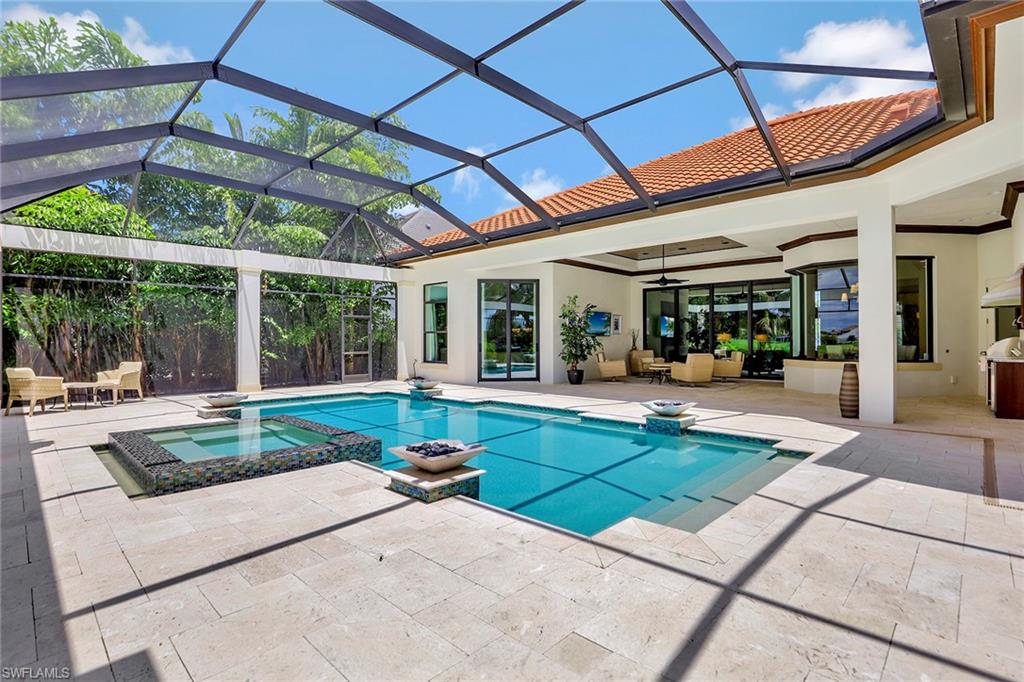 16434 Seneca Way Naples, FL 34110 - Photo 28 of 35 a view of a patio with a table and chairs under an umbrella