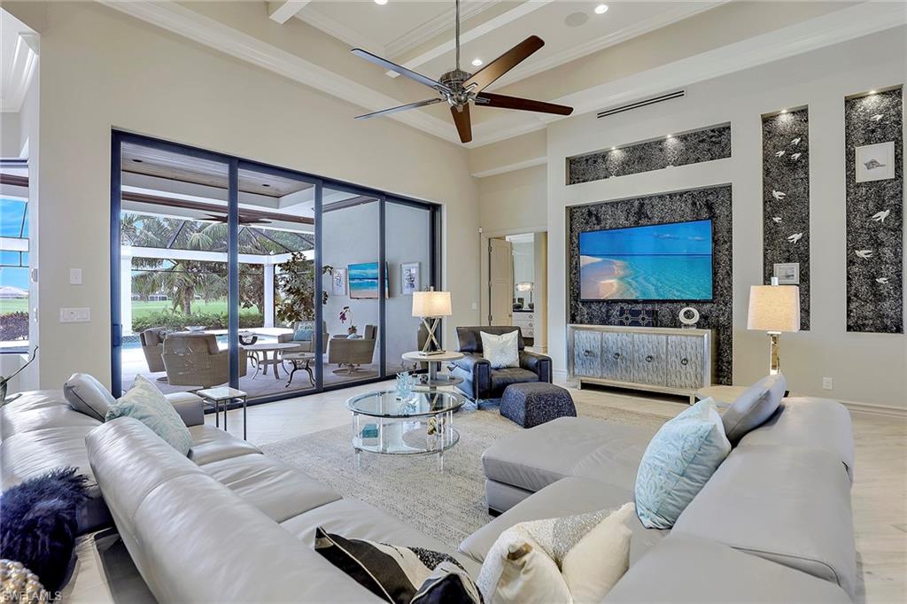 16434 Seneca Way Naples, FL 34110 - Photo 3 of 35 a living room with furniture a floor to ceiling window and a flat screen tv