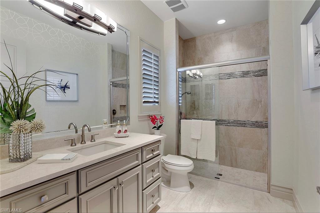 16434 Seneca Way Naples, FL 34110 - Photo 34 of 35 a bathroom with a granite countertop sink toilet and shower
