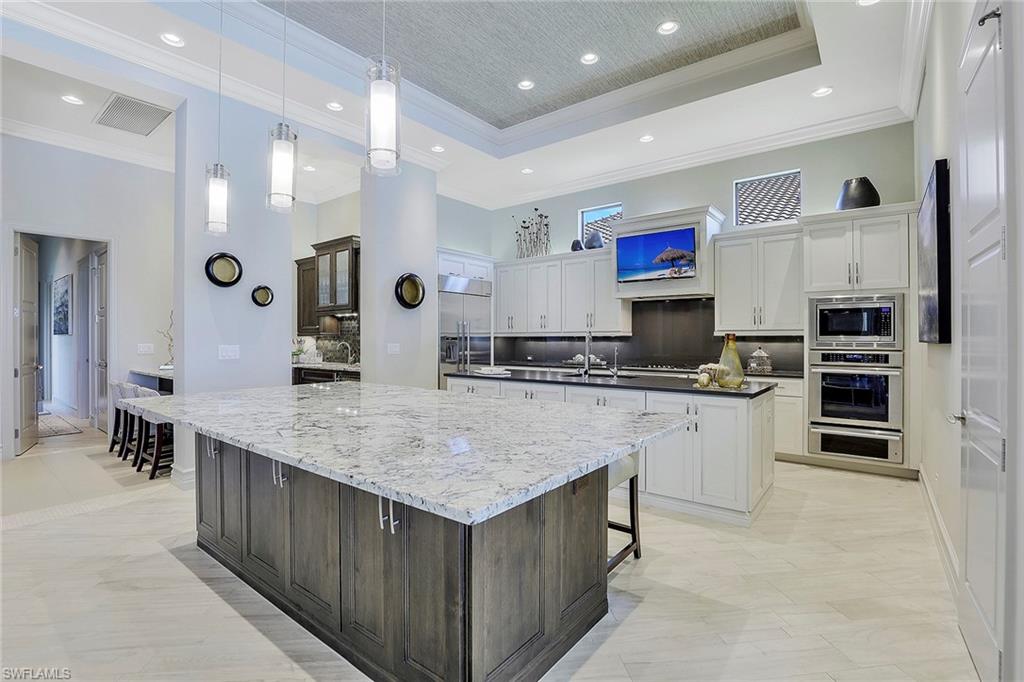 16434 Seneca Way Naples, FL 34110 - Photo 6 of 35 a kitchen with stainless steel appliances granite countertop a kitchen island a stove a refrigerator a sink a oven and a refrigerator