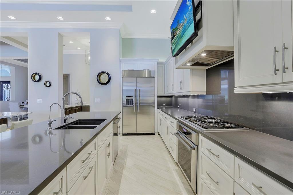 16434 Seneca Way Naples, FL 34110 - Photo 7 of 35 a kitchen with stainless steel appliances granite countertop a sink stove and cabinets