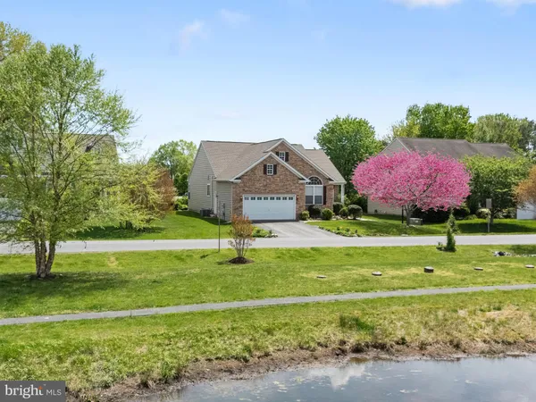a front view of a house with garden and trees