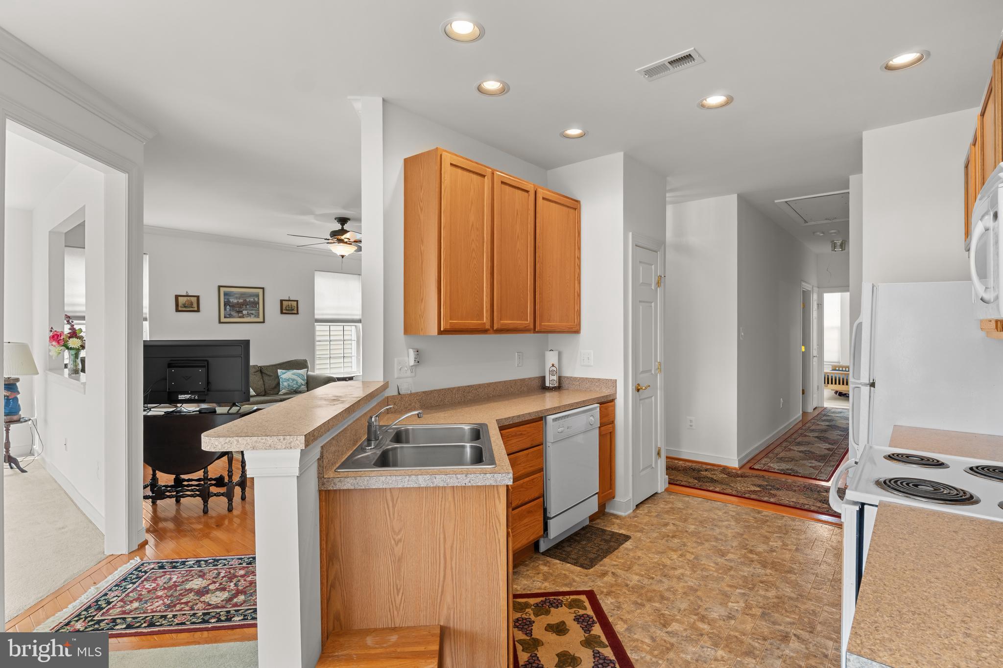 5 St George Ocean View, DE 19970 - Photo 13 of 29 a kitchen with stainless steel appliances granite countertop a sink a stove a refrigerator cabinets and living room view