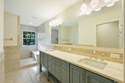 a spacious bathroom with a sink a large mirror and a bathtub