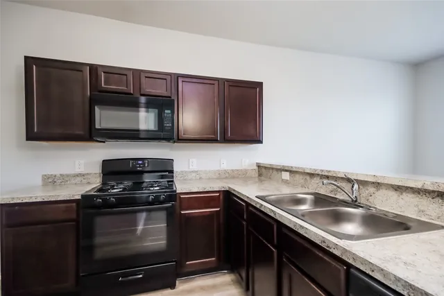 a kitchen with stainless steel appliances granite countertop a sink stove microwave and oven