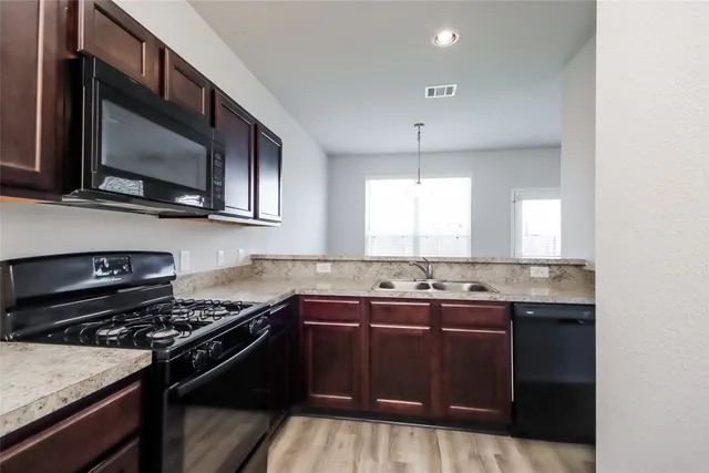 a kitchen with a sink stove and microwave