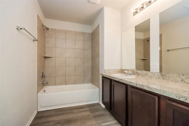 a bathroom with a granite countertop bathtub sink vanity and mirror