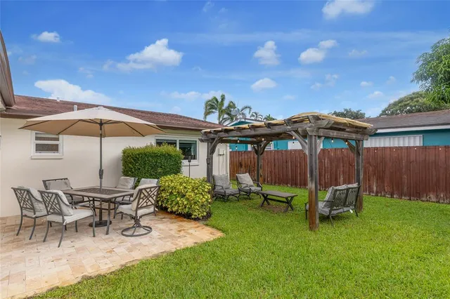 a view of a patio with a table and chairs under an umbrella