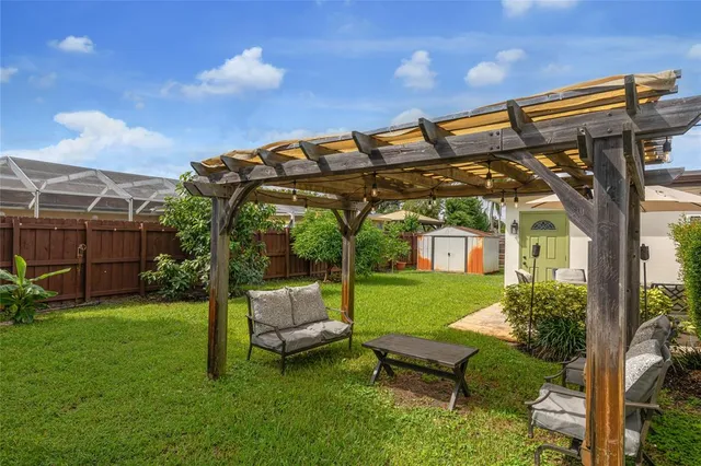 a view of a chair and table in backyard of the house