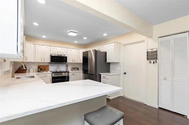 a kitchen with stainless steel appliances a refrigerator and a stove top oven