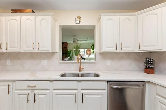 a kitchen with white cabinets and a sink