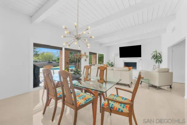 a dining room with furniture a chandelier and wooden floor