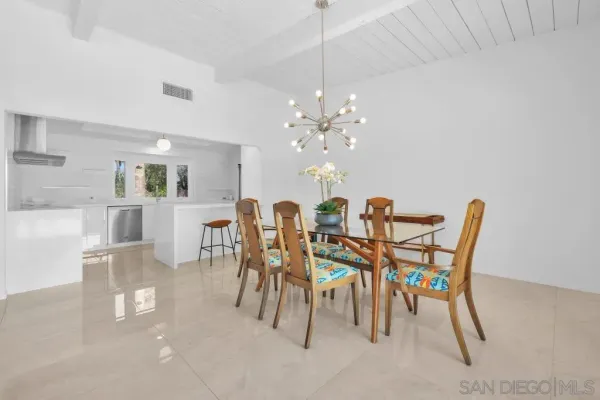 a kitchen with stainless steel appliances a stove a sink refrigerator and a chair
