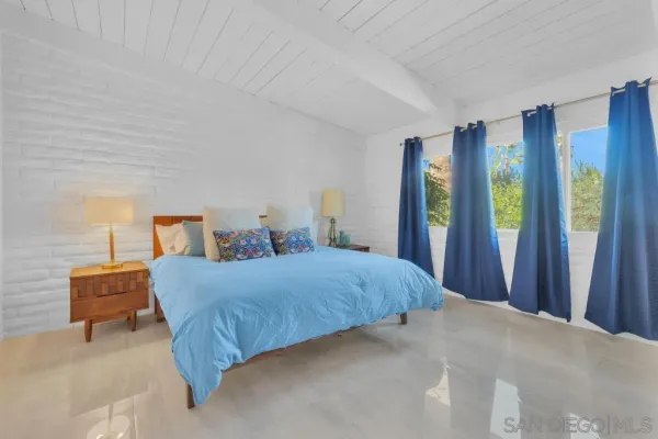 a bedroom with a bed and a lamp on table