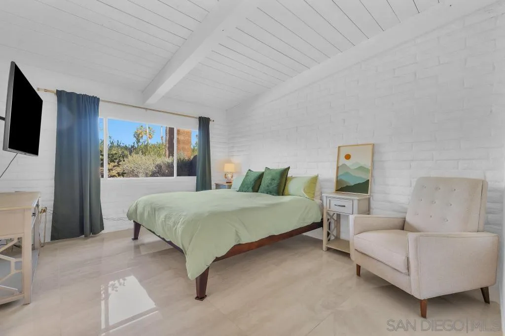 1606 Yaqui Road Borrego Springs, CA 92004 - Photo 28 of 51 a spacious bedroom with a bed a couch and a flat screen tv