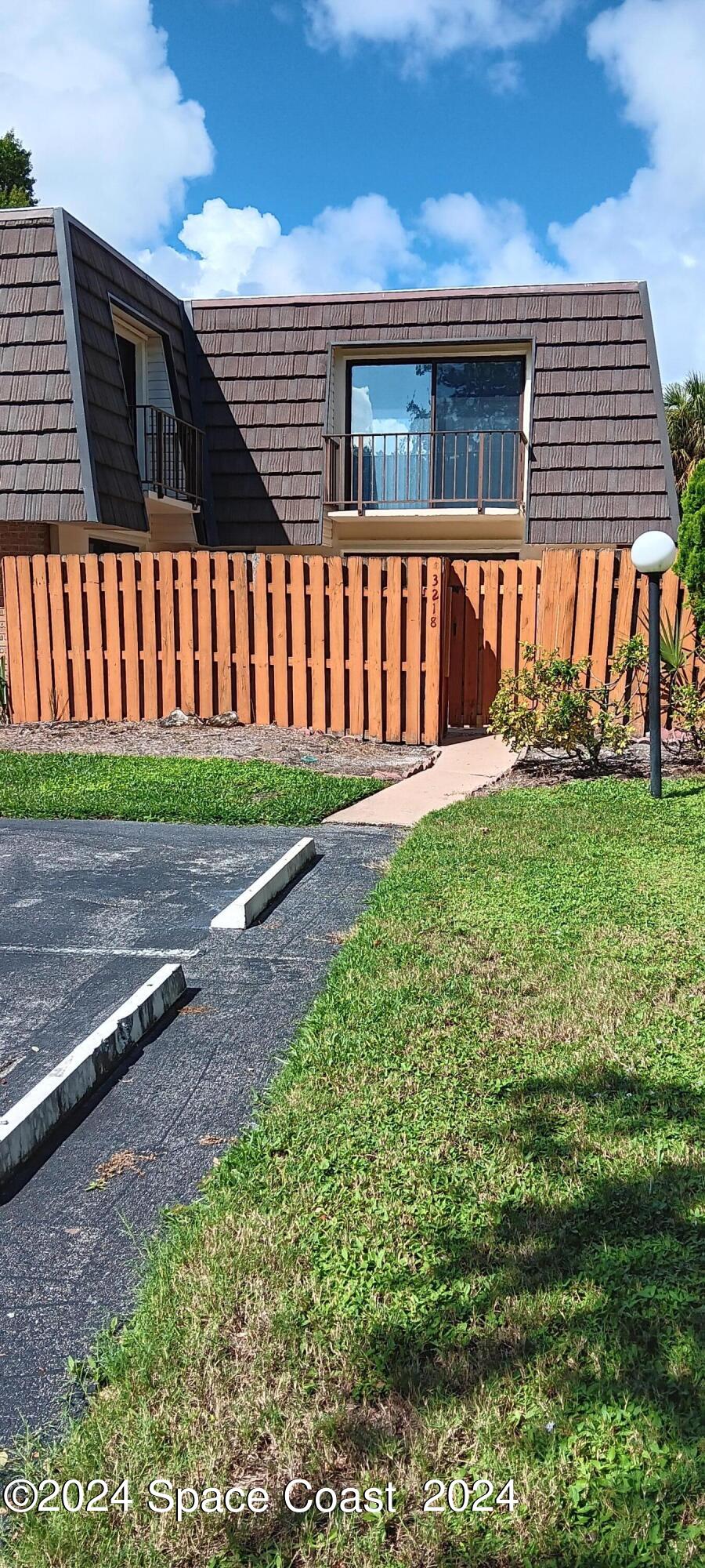 a view of a house with a yard and pathway