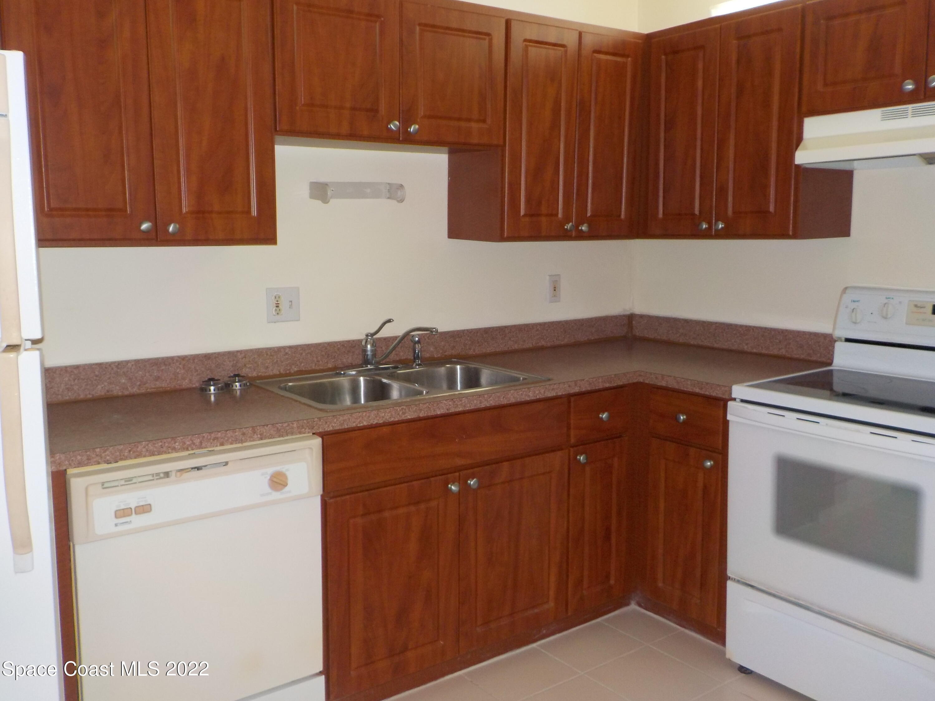3218 Vista Oaks Circle Northeast Palm Bay, FL 32905 - Photo 3 of 11 a kitchen with granite countertop a sink dishwasher stove and cabinets
