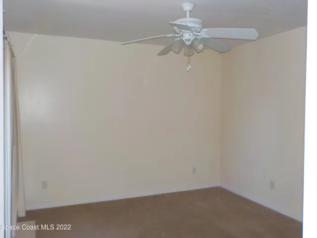 a view of a small space with a chandelier fan