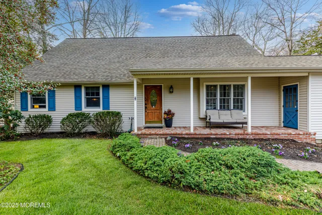 a view of a house with potted plants and a yard
