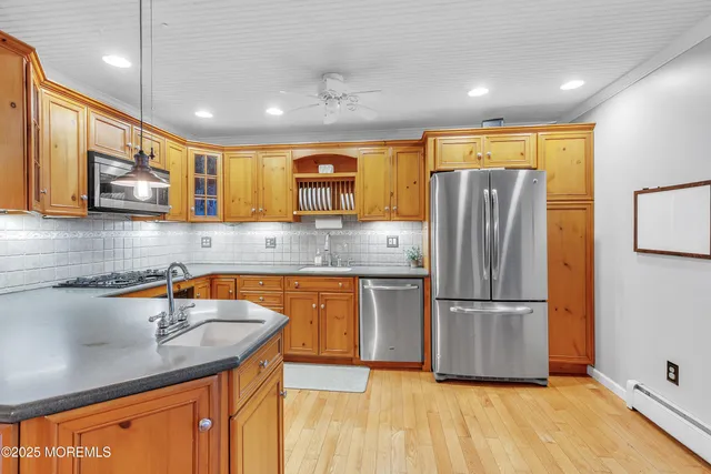 a kitchen with stainless steel appliances granite countertop a refrigerator a sink and a stove