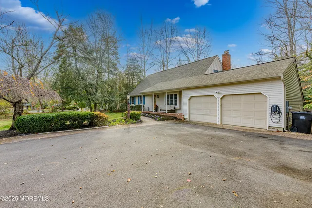a view of a house with backyard and trees