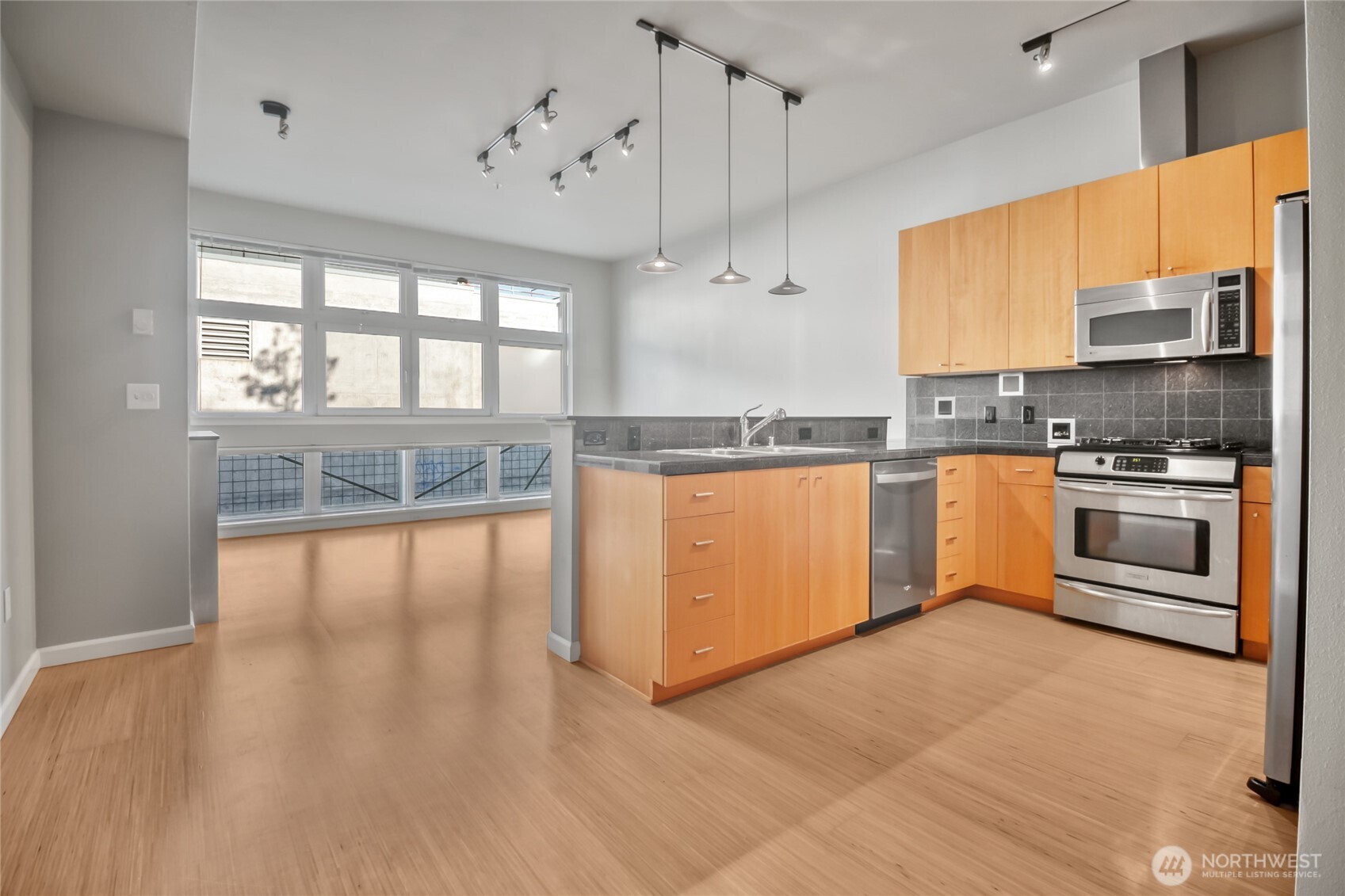 17 West Mercer Street, Unit 217 Seattle, WA 98119 - Photo 15 of 36 a kitchen with stainless steel appliances granite countertop a stove top oven a sink dishwasher a refrigerator and white cabinets with wooden floor