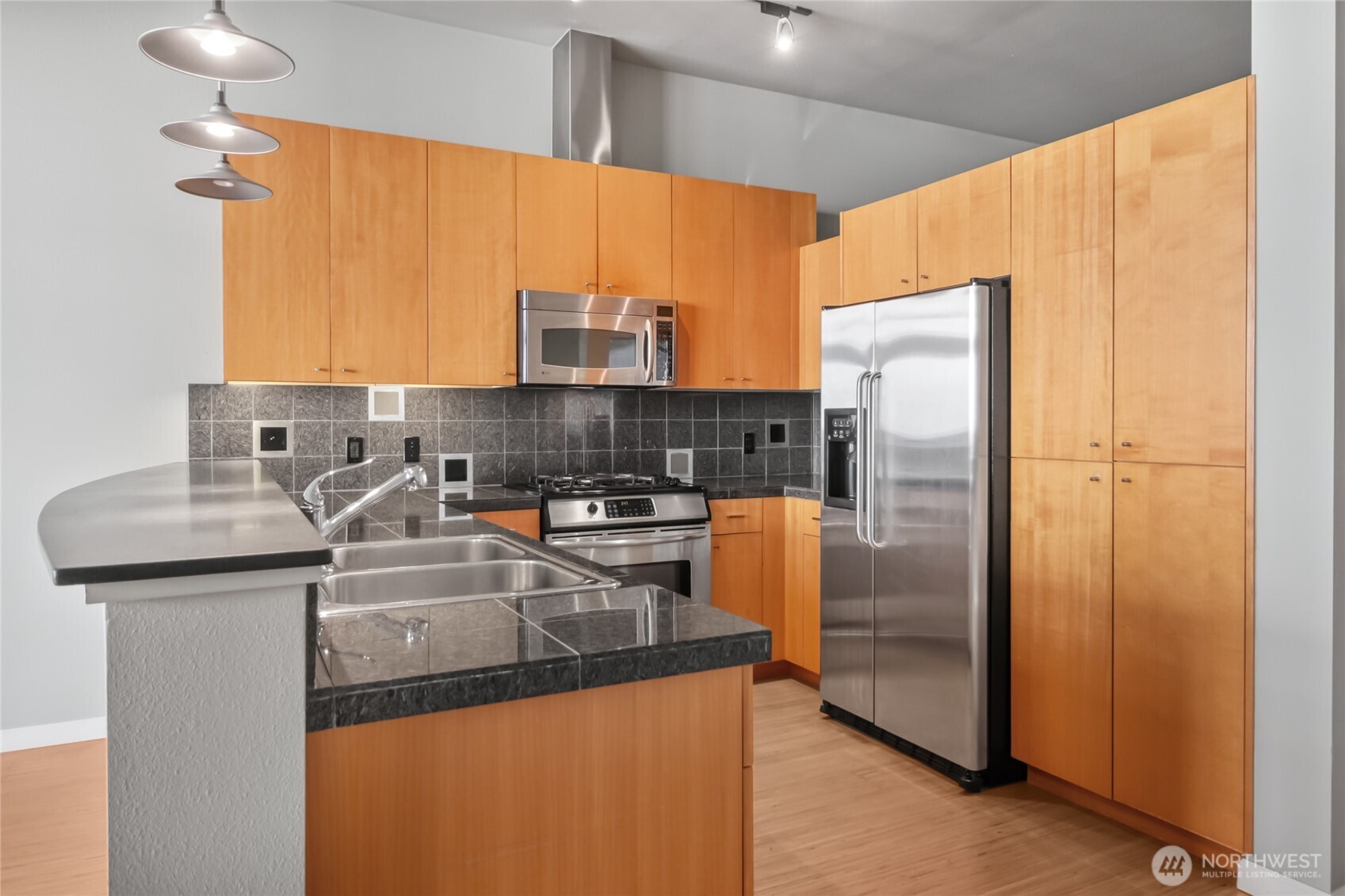 17 West Mercer Street, Unit 217 Seattle, WA 98119 - Photo 17 of 36 a kitchen with stainless steel appliances granite countertop a refrigerator a sink and a stove