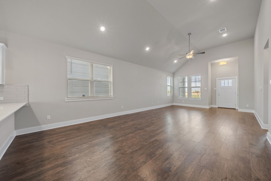 217 Pinnacle Lane Kyle, TX 78640 - Photo 11 of 33 an empty room with wooden floor and windows