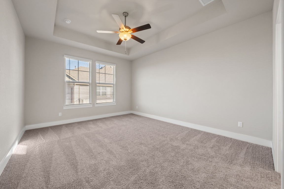 217 Pinnacle Lane Kyle, TX 78640 - Photo 14 of 33 an empty room with windows and fan