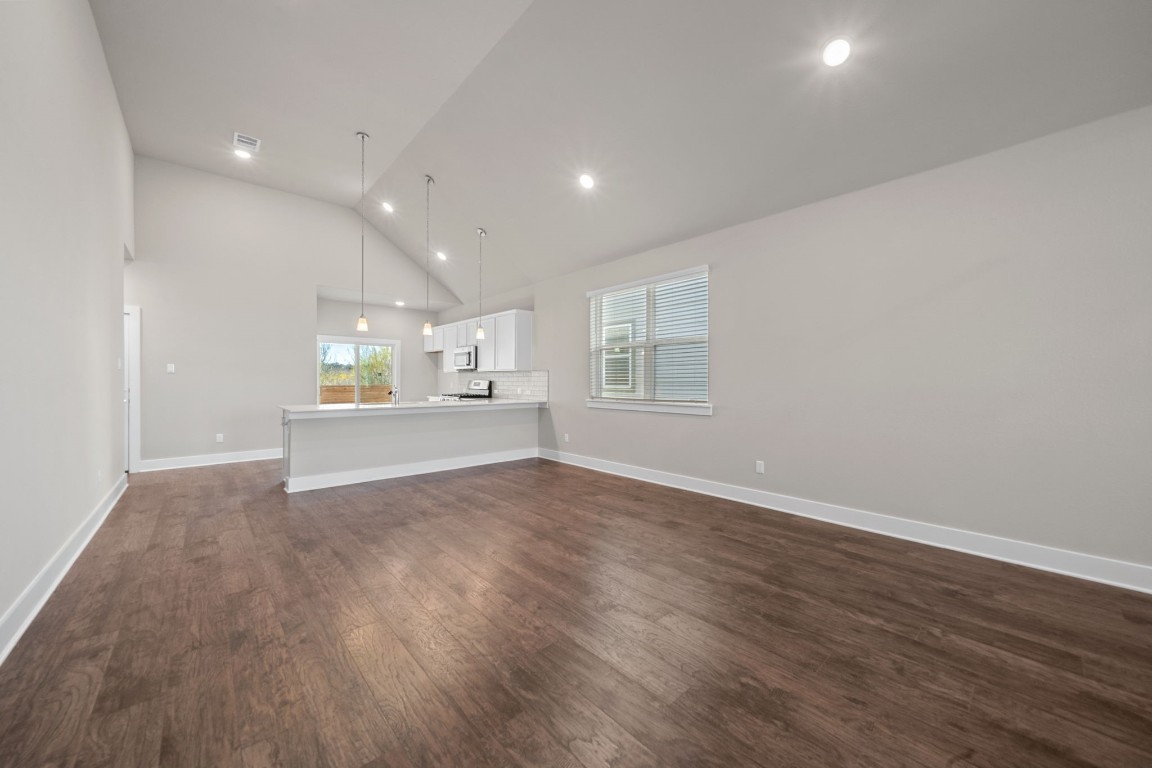 217 Pinnacle Lane Kyle, TX 78640 - Photo 6 of 33 an empty room with wooden floor and windows