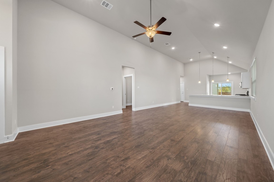 217 Pinnacle Lane Kyle, TX 78640 - Photo 7 of 33 an empty room with wooden floor and windows