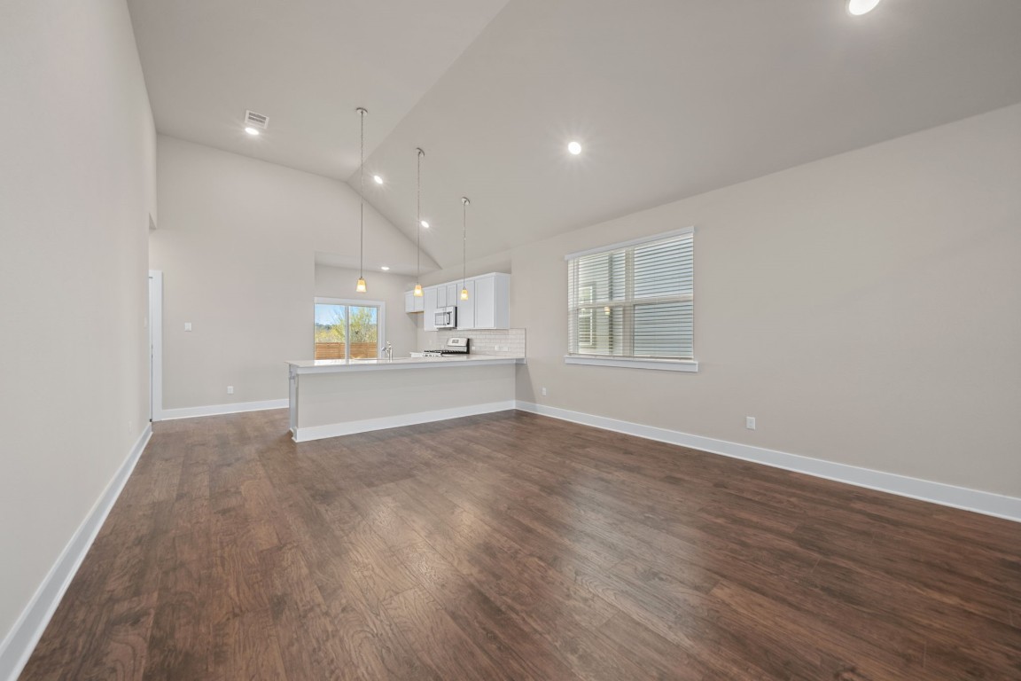 217 Pinnacle Lane Kyle, TX 78640 - Photo 8 of 33 a view of an empty room with a window and wooden floor