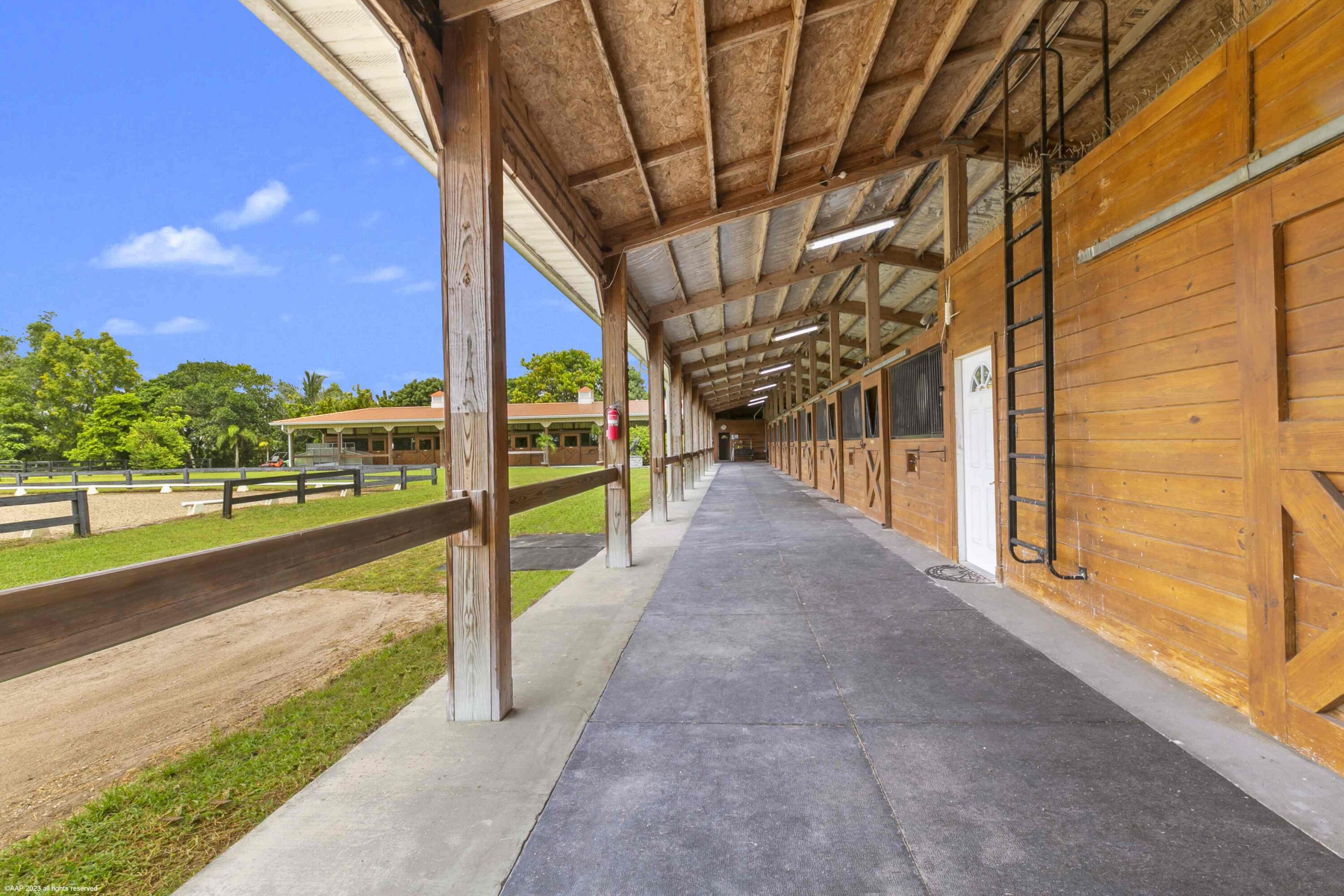 16559 Rustic Road Wellington, FL 33470 - Photo 15 of 82 a view of a swimming pool with a porch