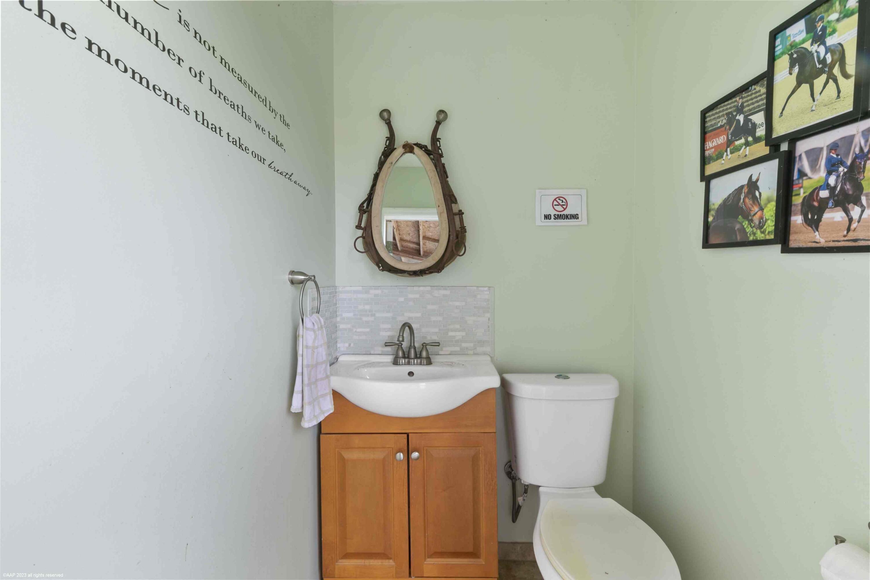 16559 Rustic Road Wellington, FL 33470 - Photo 23 of 82 a bathroom with a toilet a sink and a mirror