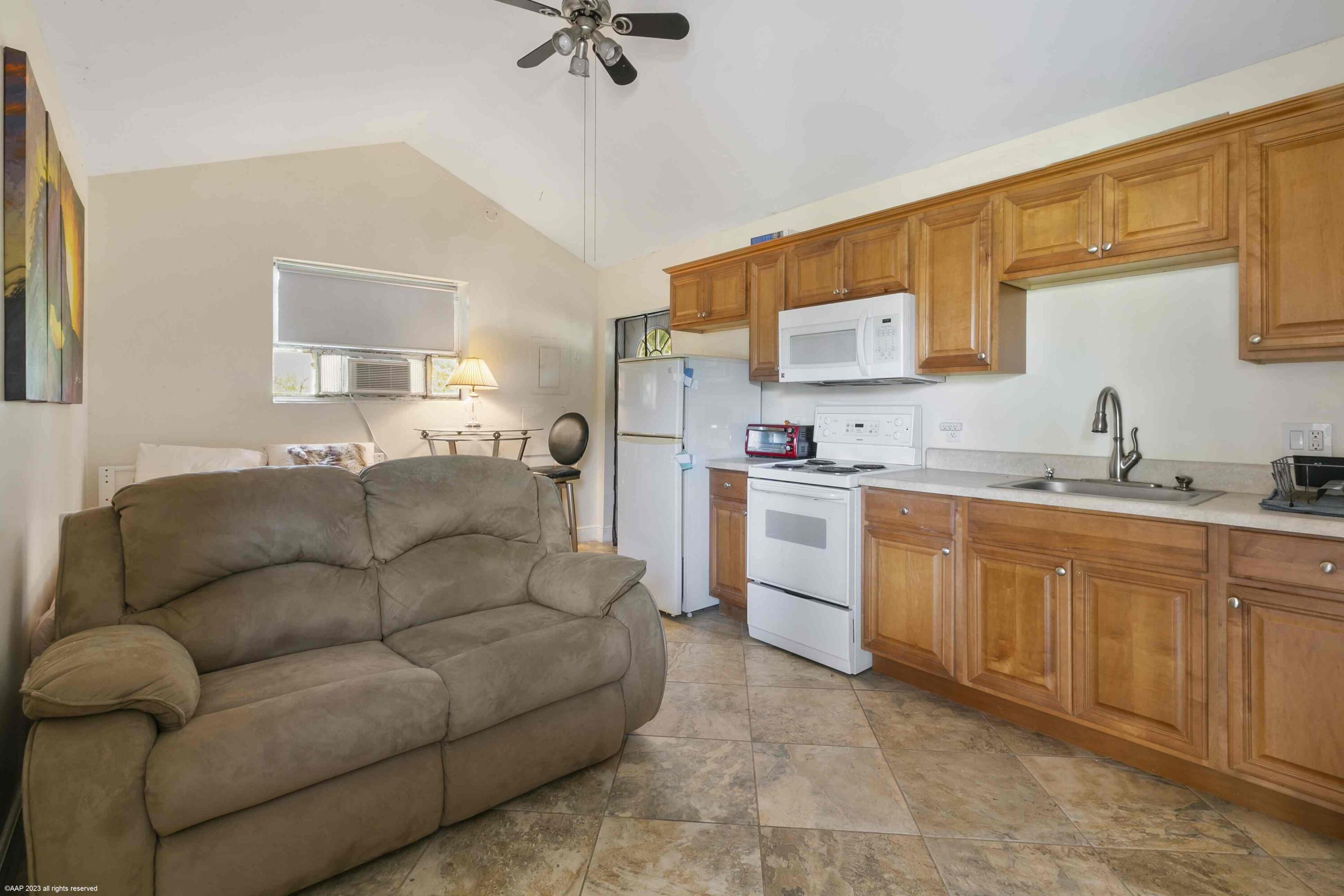 16559 Rustic Road Wellington, FL 33470 - Photo 24 of 82 a living room with furniture a sink and a refrigerator
