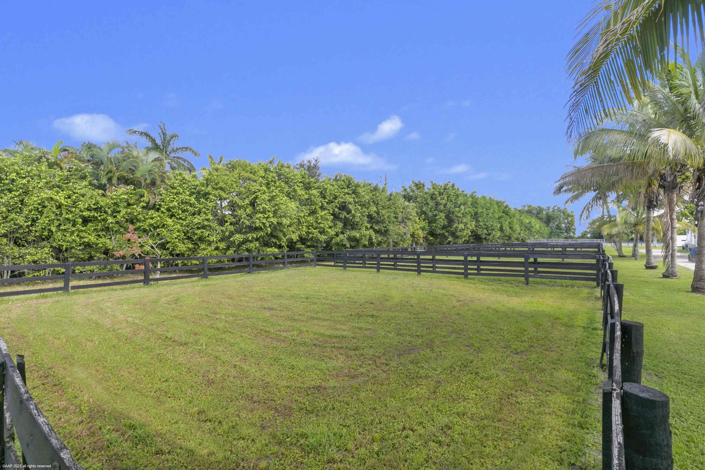 16559 Rustic Road Wellington, FL 33470 - Photo 35 of 82 a view of an ocean house a swimming pool and outdoor space