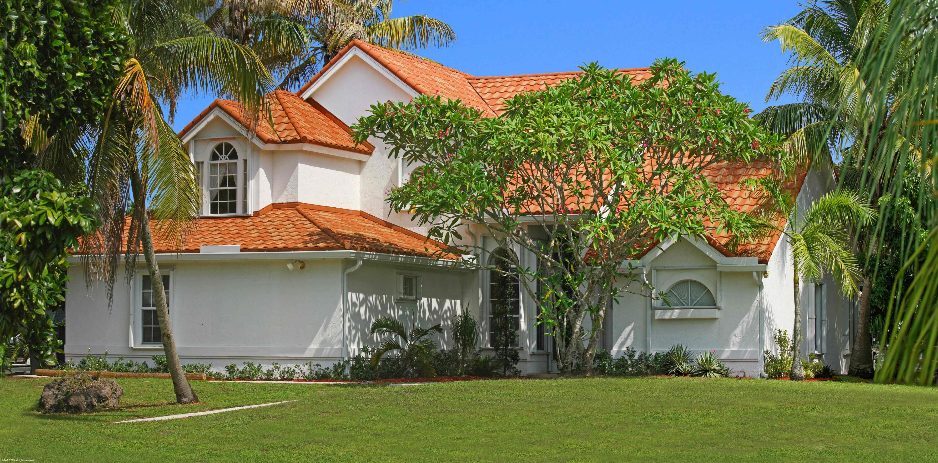 16559 Rustic Road Wellington, FL 33470 - Photo 41 of 82 a front view of a house with a yard and garage