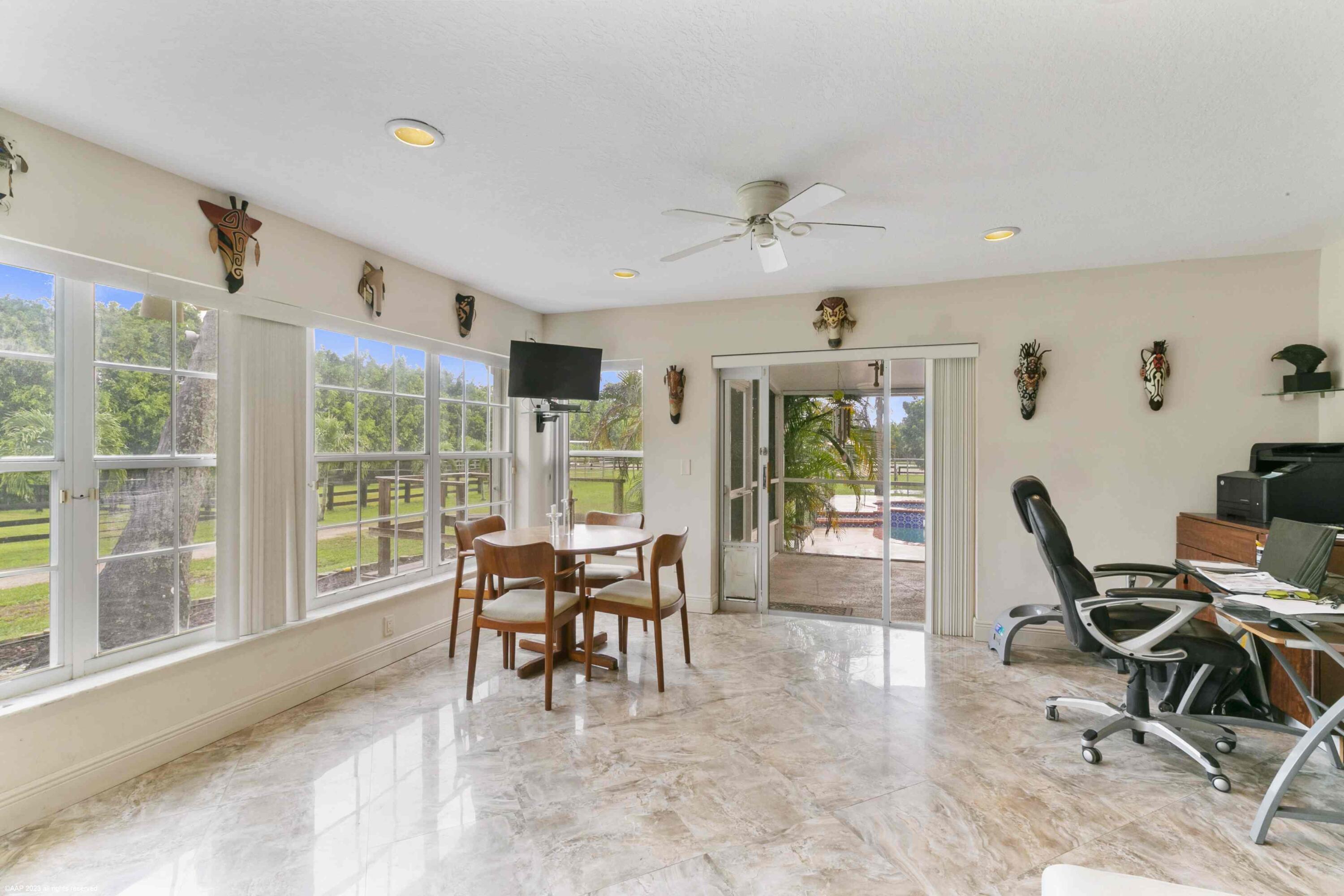 16559 Rustic Road Wellington, FL 33470 - Photo 47 of 82 a dining room with furniture and a floor to ceiling window