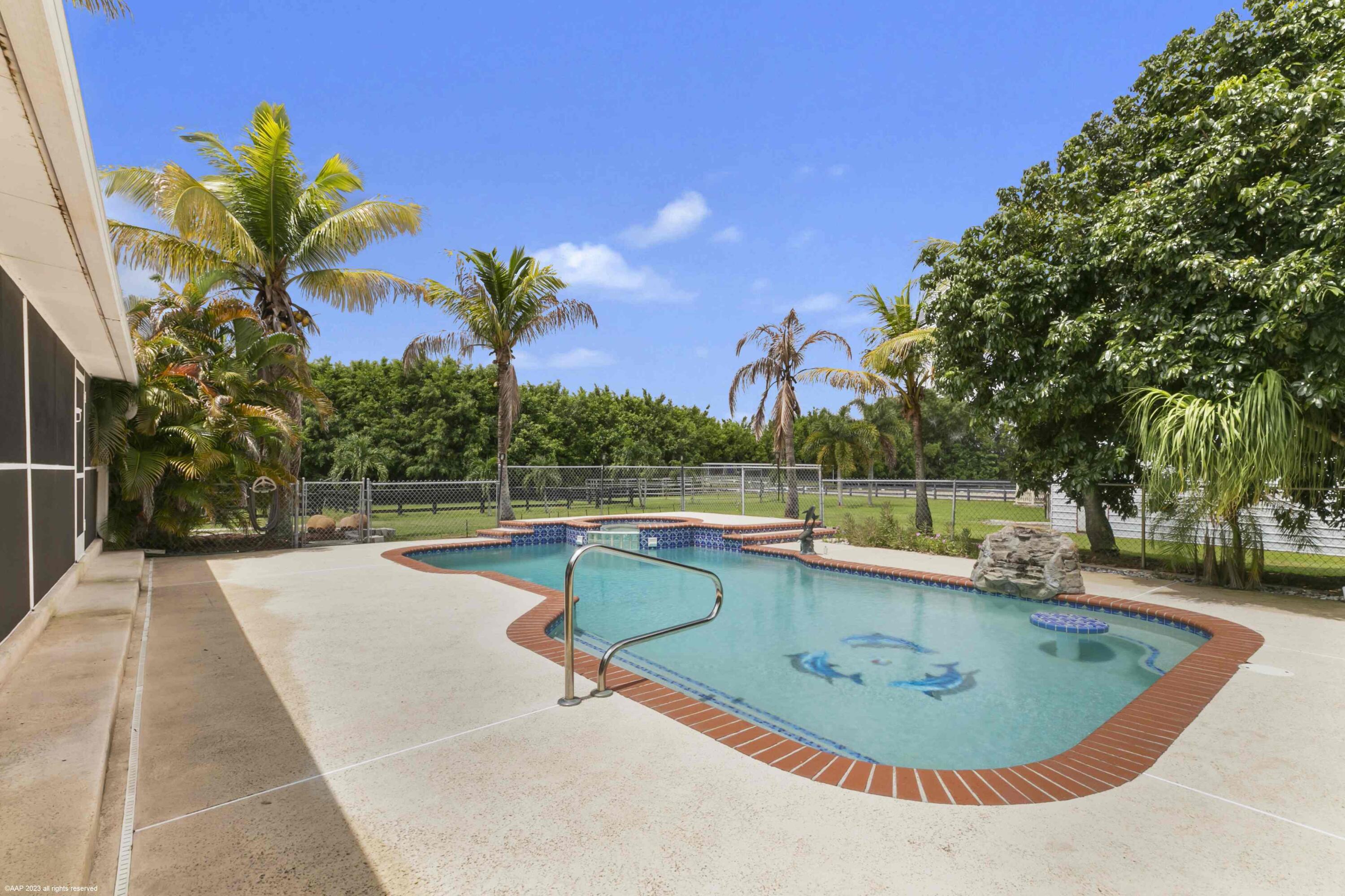16559 Rustic Road Wellington, FL 33470 - Photo 5 of 82 a view of a swimming pool with a patio