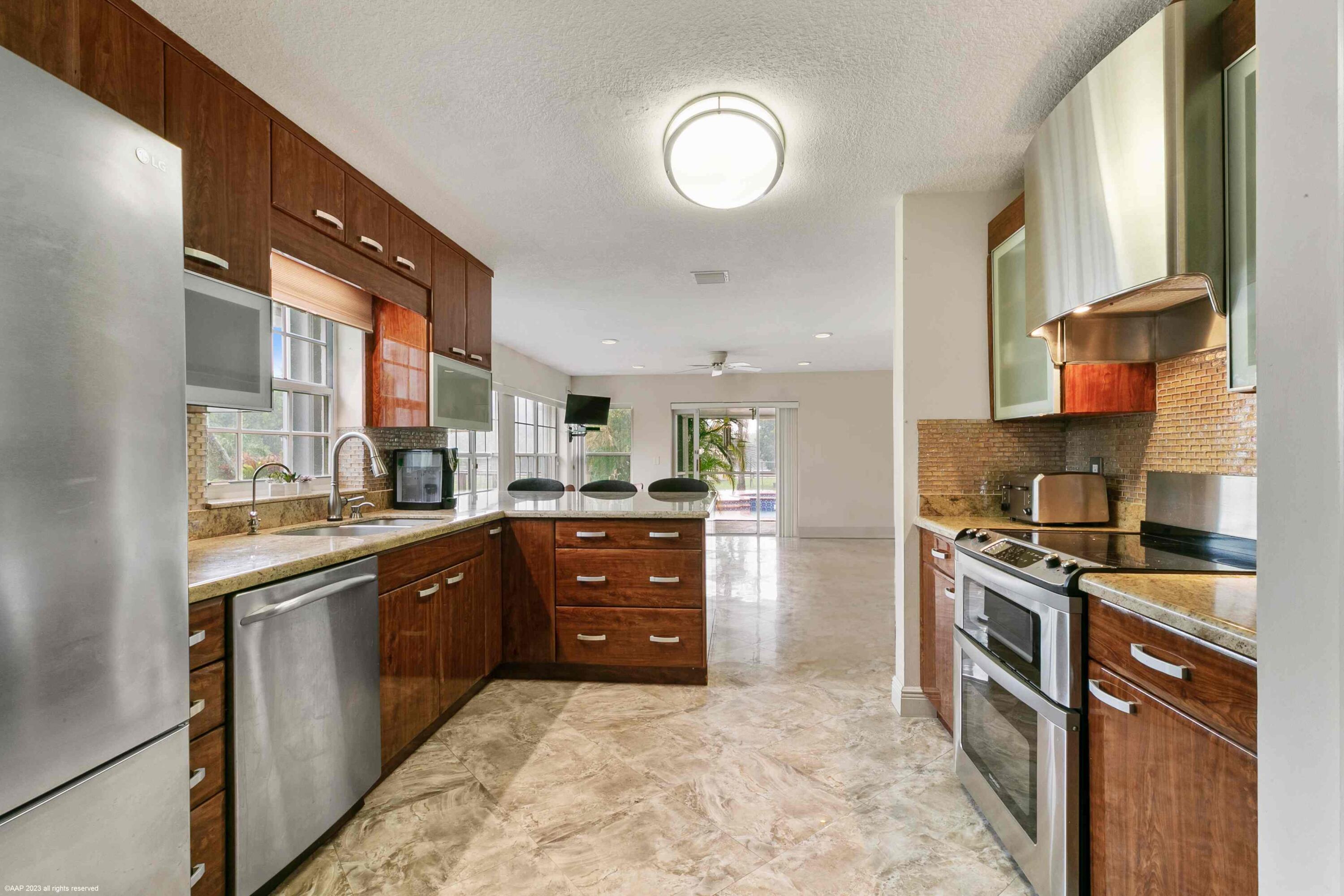 16559 Rustic Road Wellington, FL 33470 - Photo 56 of 82 a kitchen with stainless steel appliances granite countertop a stove a sink and a refrigerator