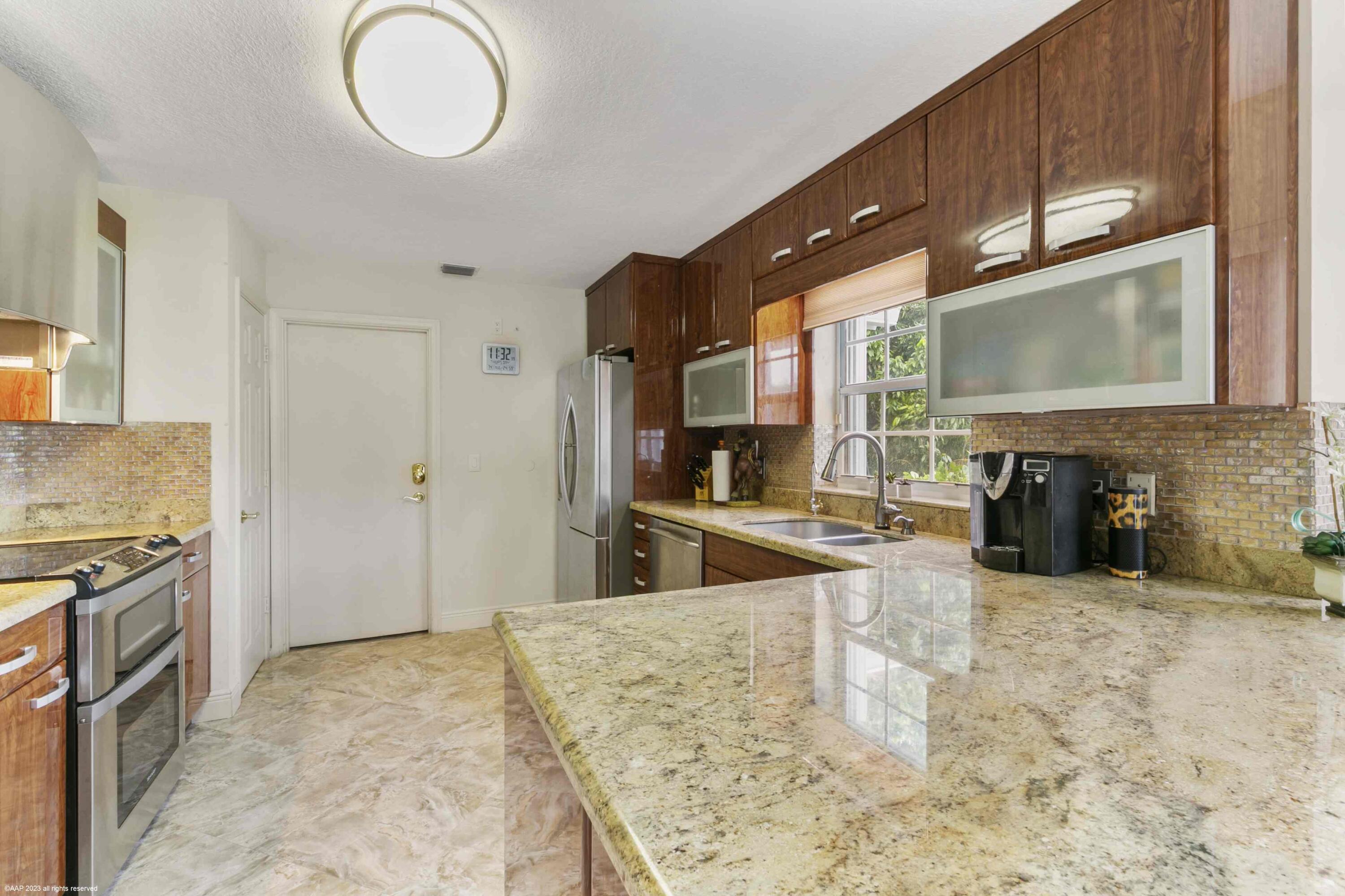 16559 Rustic Road Wellington, FL 33470 - Photo 57 of 82 a kitchen with stainless steel appliances granite countertop a sink and a stove